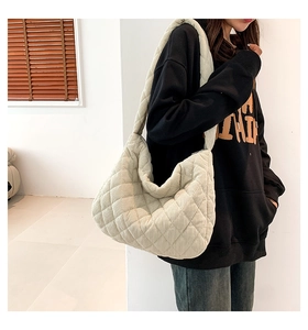 Detail view of cream quilted hobo bag featuring corduroy texture and diamond stitching