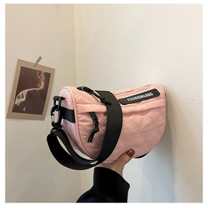 Detail of pink quilted nylon crossbody bag with adjustable strap and fashion label
