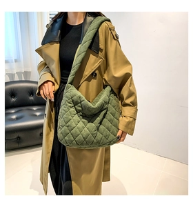 Detail of green quilted corduroy shoulder bag styled with a khaki autumn trench coat