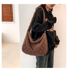 Detail of dark brown quilted corduroy hobo bag featuring a classic rhombus stitch pattern