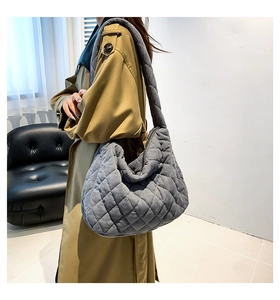 Detailed macro view of gray quilted corduroy tote bag texture with thick shoulder strap