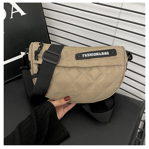 Close-up of khaki quilted crossbody bag with diamond patterns and adjustable strap