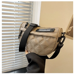 Detail of khaki quilted crescent bag with adjustable black strap and fashion label
