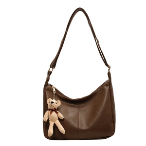 Bolso tote vintage de cuero PU marrón con un lindo colgante de oso sobre fondo blanco puro