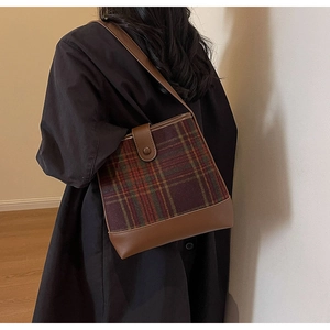 Détail d'un sac à main à carreaux avec garniture en cuir et fermoir en métal élégant