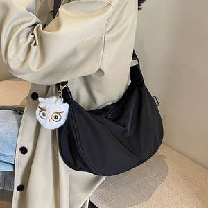 Fashionable black nylon dumpling bag for women with a cute white owl bag charm