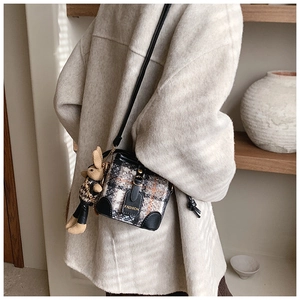 Close-up of checkered plaid mini bucket bag with fashion leather patch and cute bunny charm