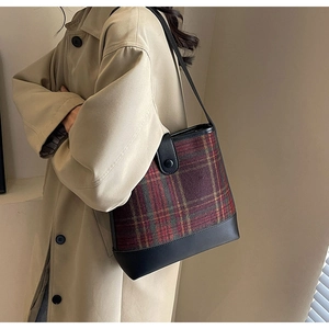 Détail du sac seau vintage à carreaux avec tissu texturé et finitions en cuir noir