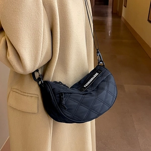 Women's black quilted crossbody crescent bag with diamond pattern and brand label