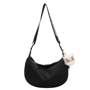 Black nylon crescent crossbody bag with adjustable fashion strap and owl plush pendant