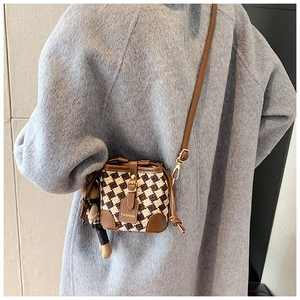 Detail of checkered bucket bag with leather drawstring and cute doll charm