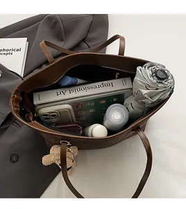 Spacious brown leather tote bag interior showing large capacity for books and tablet