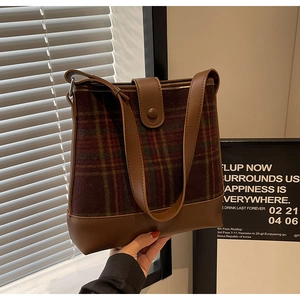 Détail du sac seau à carreaux vintage avec bandoulière en cuir et fermoir à boucle