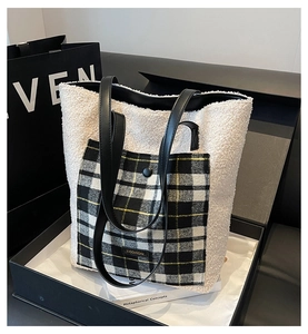 Detail of plush faux fur tote bag with plaid pocket and black leather shoulder strap