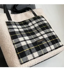 Detail of beige faux shearling tote bag with plaid pocket and black leather handle