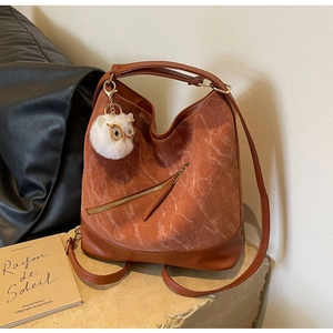 Detail of vintage brown corduroy tote bag featuring leather base and cute owl pendant