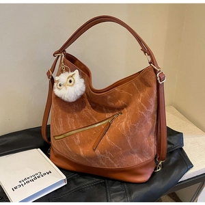 Brown corduroy tote bag detail showing leather trim and plush owl pendant decoration