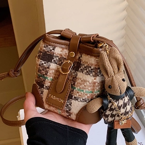 Chic checkered bucket bag with brown leather trim and cute rabbit doll keychain