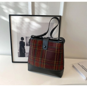 Détail du sac seau vintage à carreaux rouges montrant la laine et le cuir
