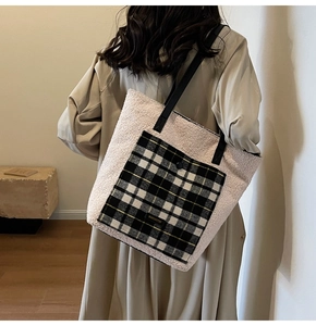 Detail of the fuzzy lamb wool tote bag with a black and white plaid pocket and leather straps