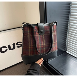 Gros plan du sac cabas en tissu écossais marron vintage et similicuir noir élégant