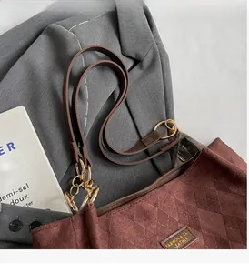 Close-up of brown suede tote bag featuring quilted texture and sturdy handles