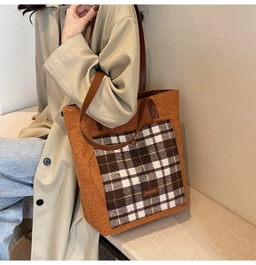 Detail of plush faux shearling tote bag with a checkered pocket and leather shoulder strap