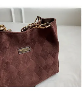 Close-up of deep burgundy quilted tote bag with gold chain strap and soft matte texture