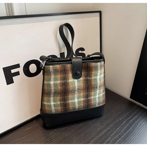 Détails du tissu à carreaux du sac seau et de la fermeture à bouton en cuir noir