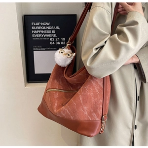 Brown corduroy tote bag with owl pompom detail shown on model in khaki coat