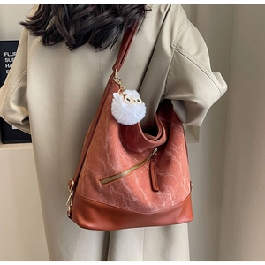 Detailed texture of brown corduroy hobo bag with white cat plush pendant charm
