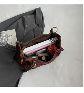 Macro view of brown suede tote bag interior showing large capacity and zipper pocket