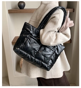 Black quilted down tote bag with wide padded shoulder straps and waterproof nylon finish