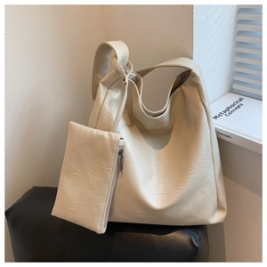 Detailansicht der großen cremefarbenen Hobo-Tasche mit passendem Beutel auf Display