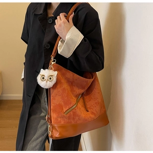 Detail of corduroy tote bag with leather bottom and cute white owl plush charm