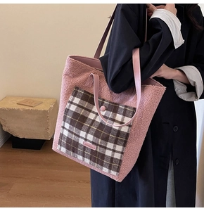 Close-up of pink fleece tote bag with a checkered front pocket and leather straps
