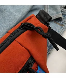 Detail des glatten Metallreißverschlusses und Nylonziehers an der orangefarbenen Segeltuchtasche