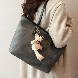 Dark gray large capacity tote bag with black shoulder straps and a knitted bear pendant