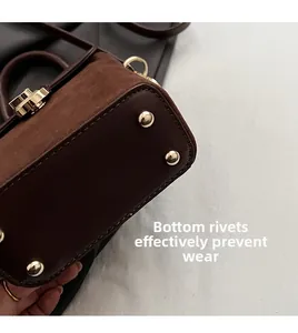 Detail of vintage suede crossbody bag showing gold bottom rivets for wear protection
