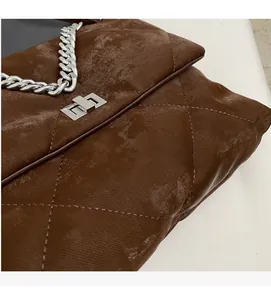 Détail du sac bandoulière matelassé marron vintage avec chaîne argentée et fermoir