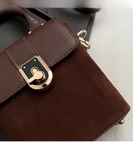 Detailed shot of vintage brown satchel with suede trim and golden metal lock