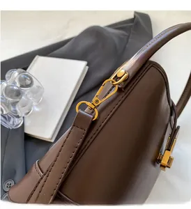 Détails de la boucle dorée vintage et du cuir marron foncé du sac seau