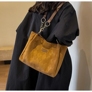 Detail of brown quilted tote bag showing vintage suede texture and chain strap