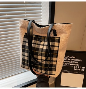 Detail of fuzzy faux shearling tote bag featuring a black and white checkered front pocket