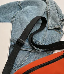 Details des verstellbaren schwarzen Nylonriemens an einer orangefarbenen Canvas-Tasche
