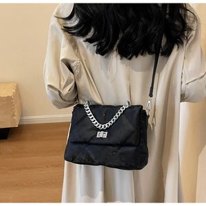 Détail du sac à bandoulière matelassé noir avec poignée chaîne argentée et fermoir pivotant