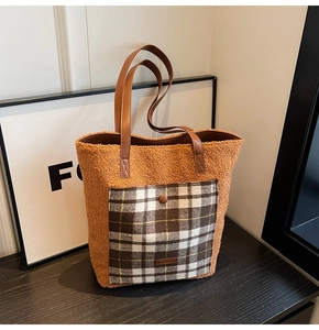 Close-up of caramel fleece tote bag with plaid pocket and leather handles