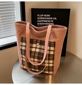 Close-up of pink faux fur tote bag with brown plaid pocket and leather straps