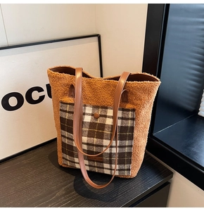 Detail of plush orange-brown teddy fleece tote bag with plaid pocket and leather straps