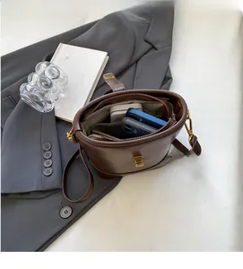Vue intérieure du sac seau en cuir marron foncé montrant l'espace pour mobiles